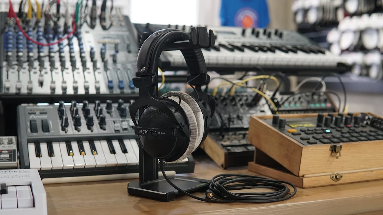 who-we-are-img High-quality headphones and music production equipment in a modern studio setting.